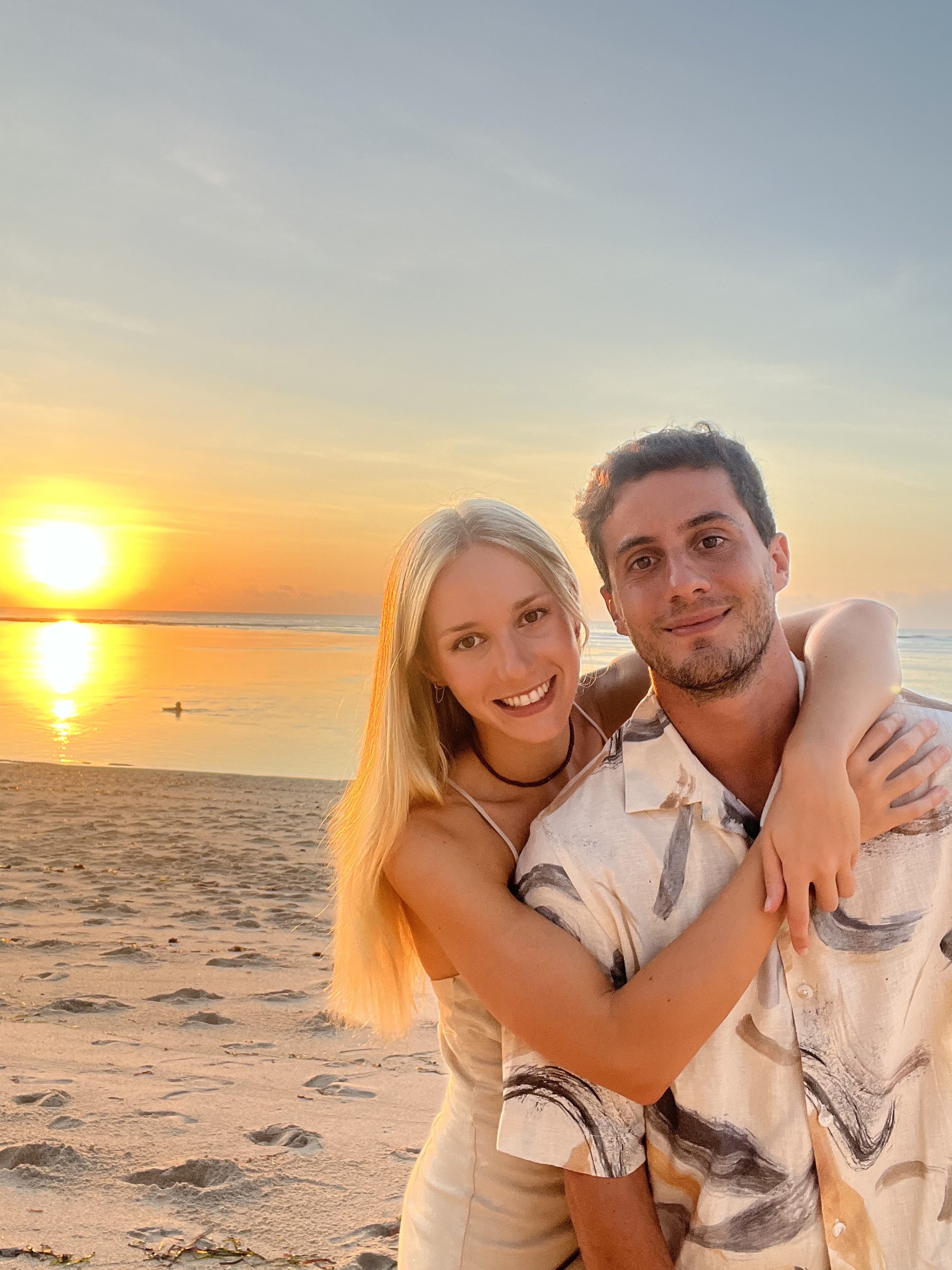 Pareja abrazándose en la playa al atardecer